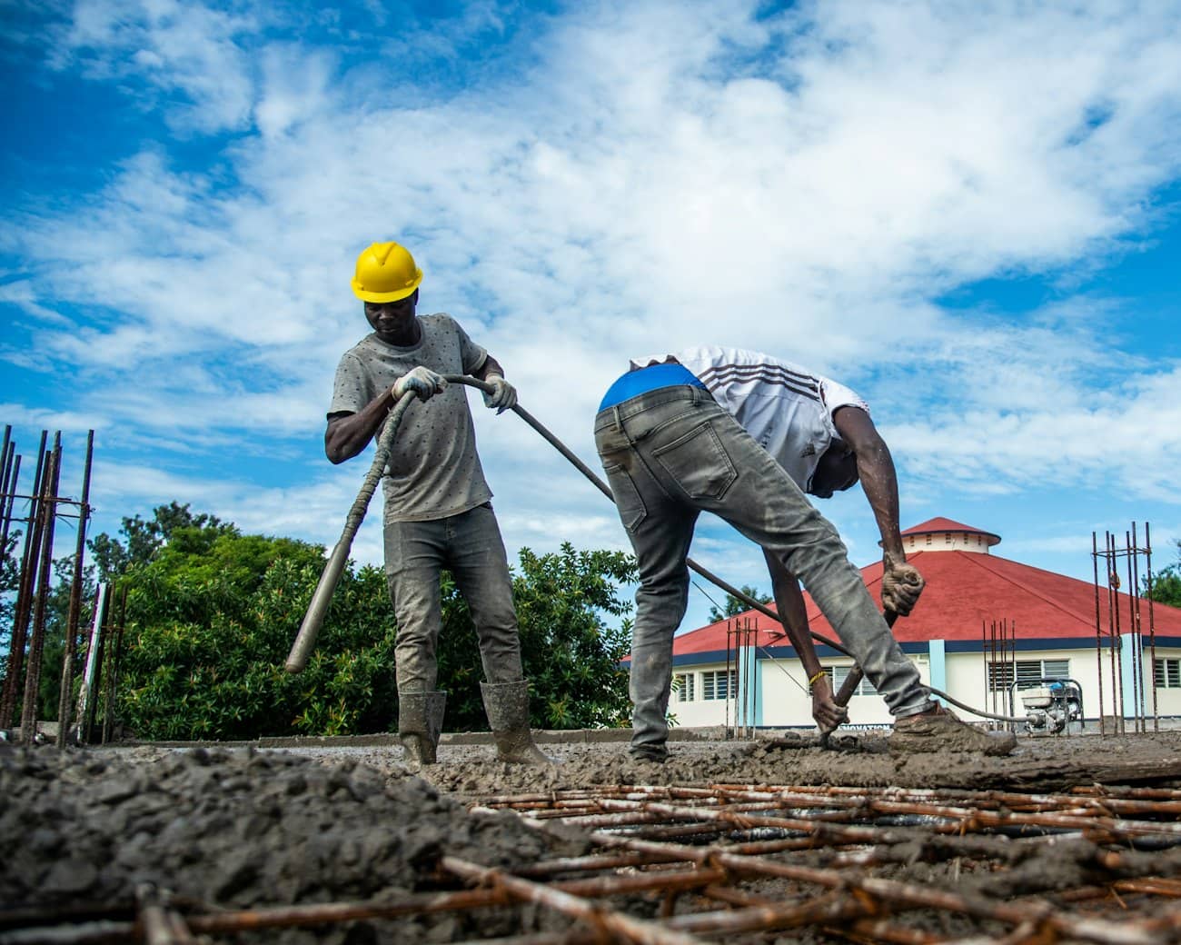 Ouvriers coulant une dalle de béton sur un chantier de logements